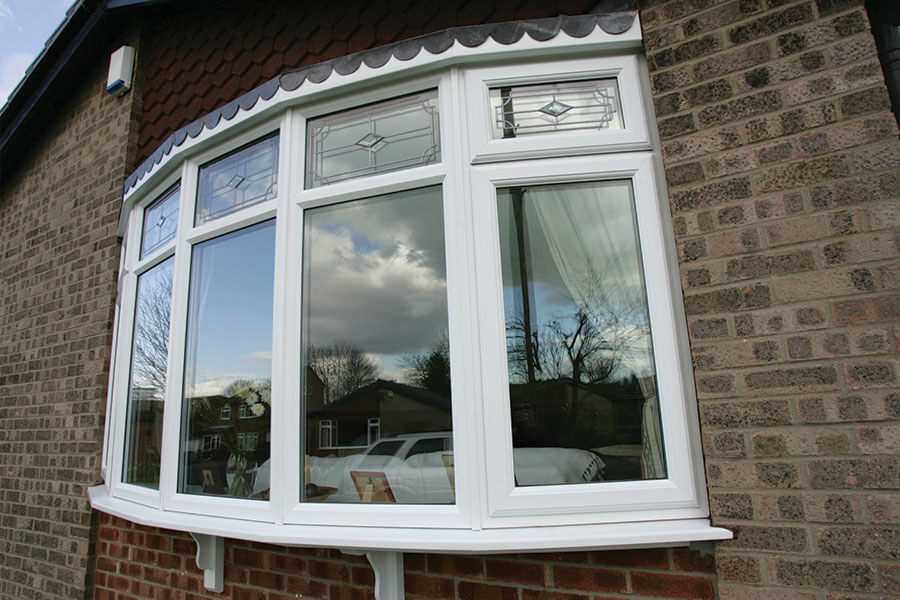 Exterior view of a white bow uPVC window with multiple rounded panes. The window design protrudes from the building, enhancing the facade and allowing for ample natural light while offering a clear view of the outside.