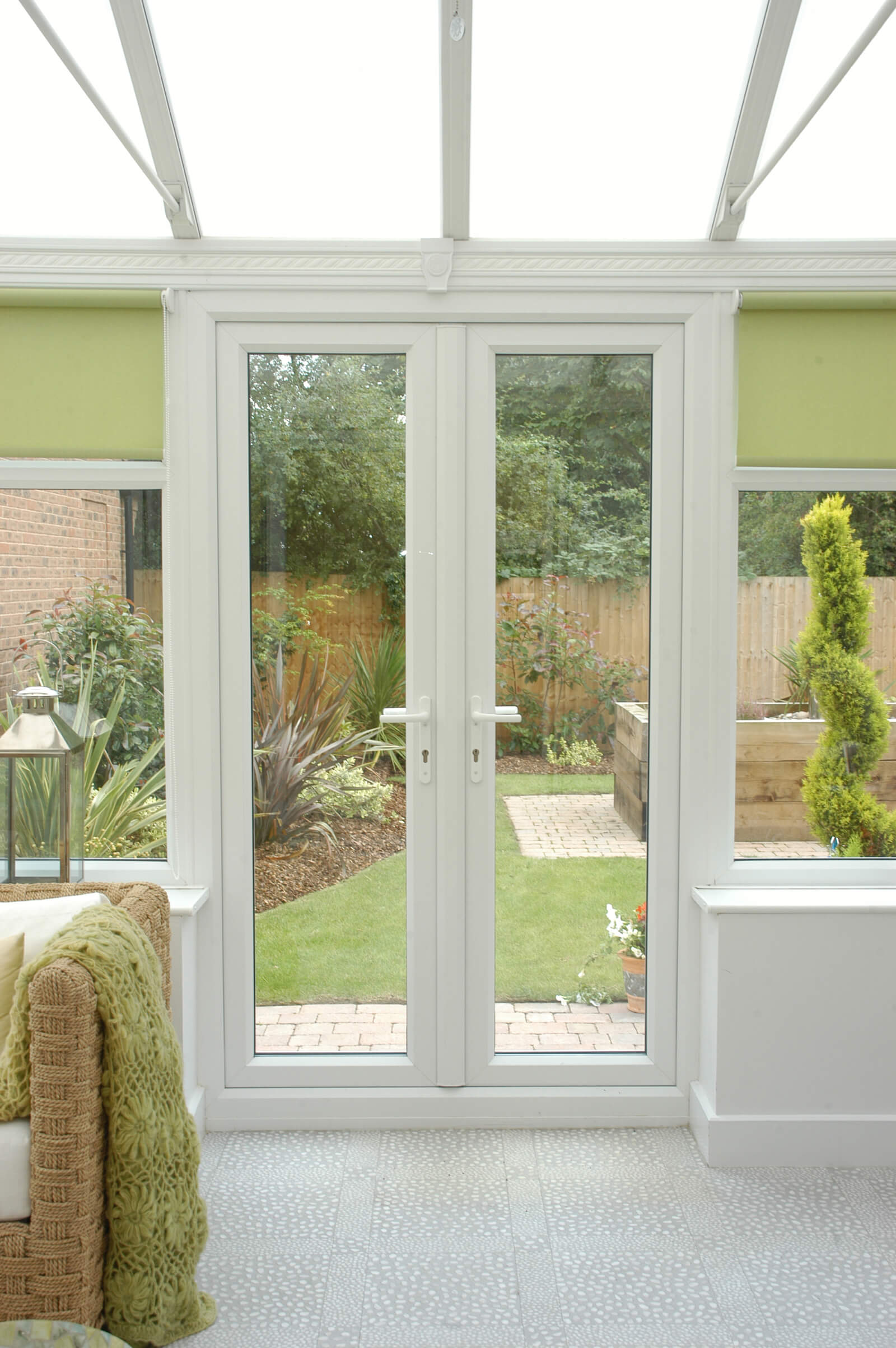 Conservatory with white French doors leading to garden area