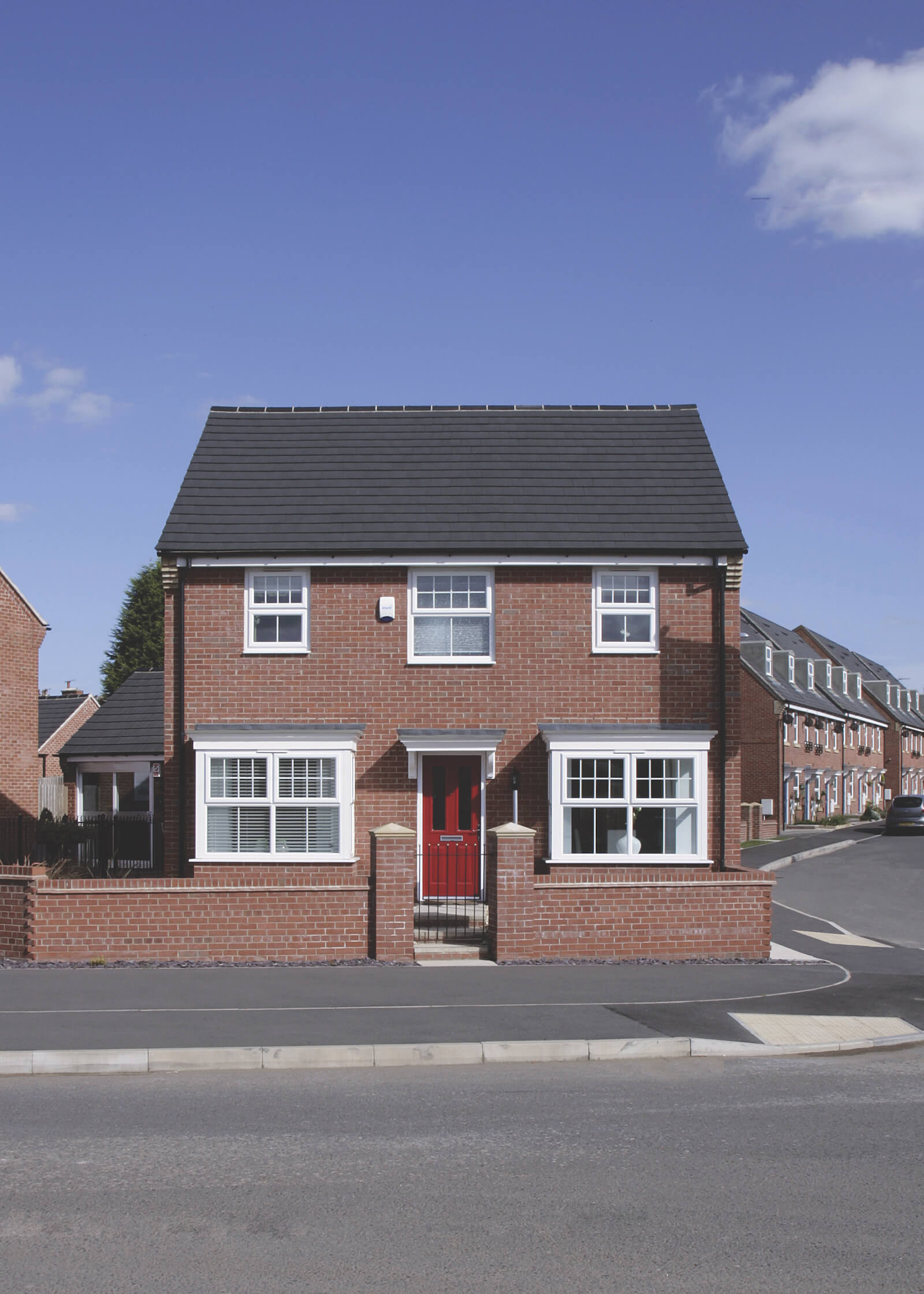 House with white uPVC windows and red entrance door