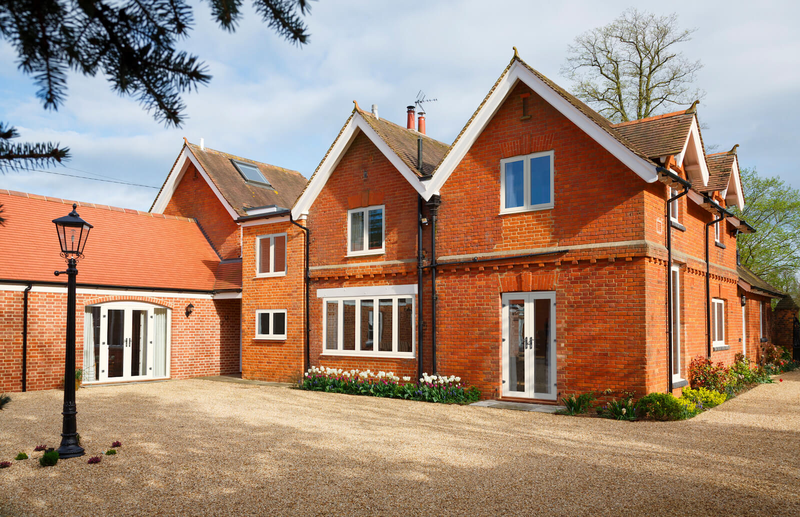 Large house with white French doors with classic lamp post outside