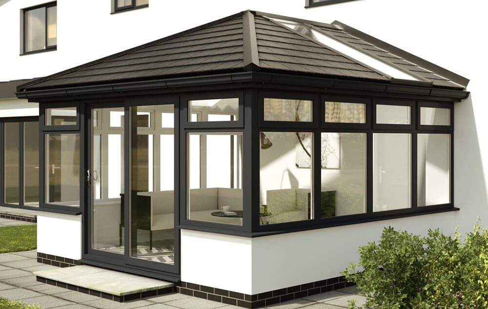 Exterior view of a house featuring an Equinox solid roof conservatory extension. The conservatory has a modern design with a gray tiled pitched roof that matches the overall aesthetic of the home.